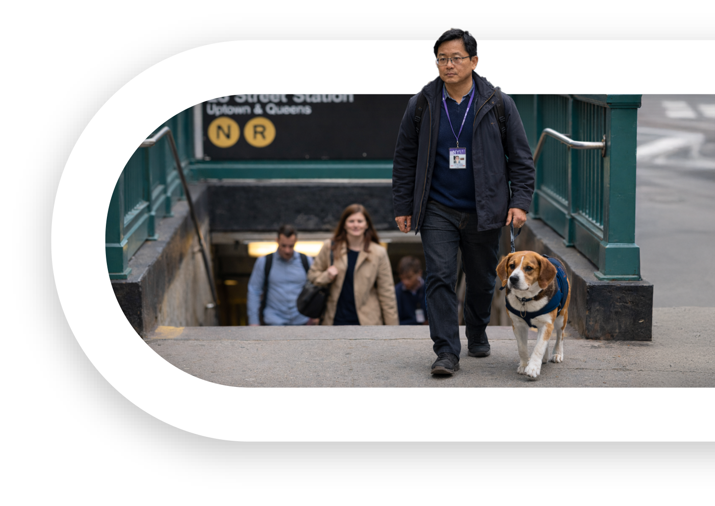 A focused service dog team exits a busy NYC subway station, demonstrating calm, reliable teamwork amid the hustle and bustle.